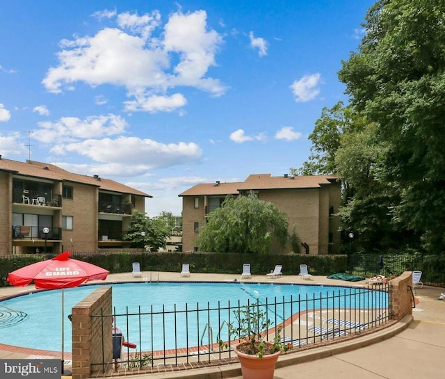 community pool featuring a patio and fence