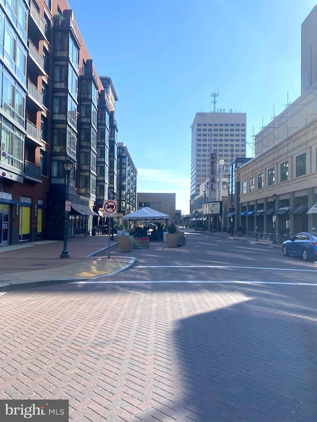 view of road featuring sidewalks, a view of city, traffic signs, and curbs