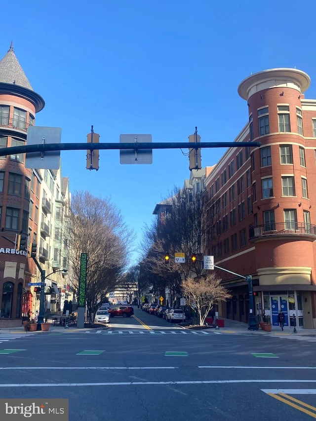 view of street with traffic lights, street lighting, curbs, and sidewalks