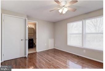 interior space with baseboards, ensuite bath, wood finished floors, and a ceiling fan