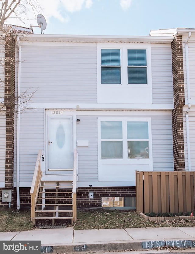 view of property featuring entry steps and fence