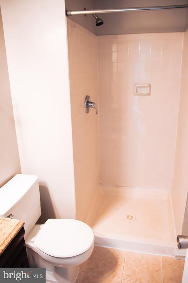 bathroom featuring vanity, toilet, a stall shower, and tile patterned flooring