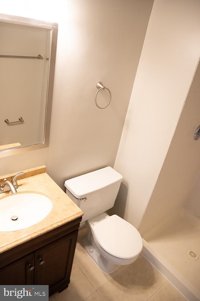 bathroom featuring vanity, tile patterned floors, toilet, and a stall shower