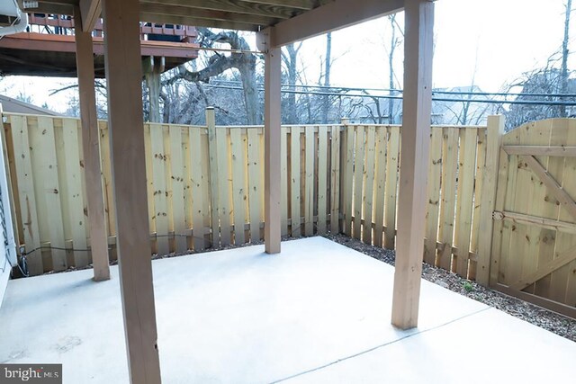 snow covered patio with a fenced backyard