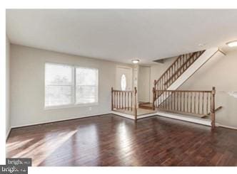 unfurnished living room featuring stairway and wood finished floors