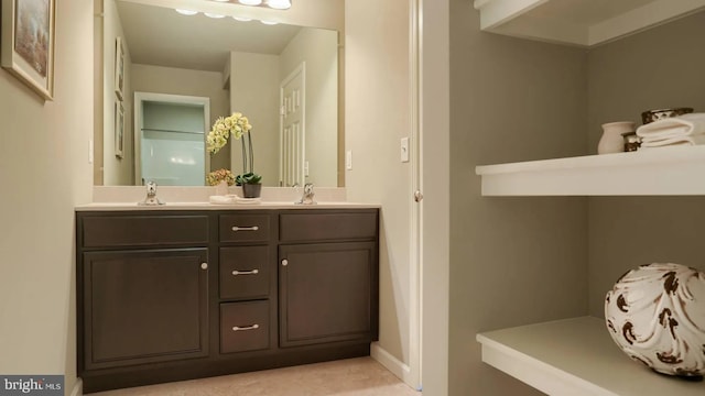 full bathroom with double vanity, baseboards, and a sink