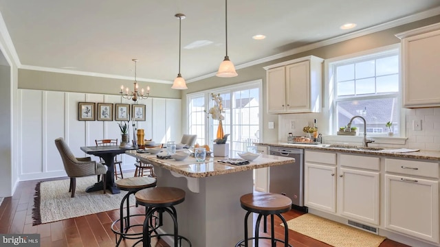 kitchen with visible vents, dark wood finished floors, dishwasher, backsplash, and a sink