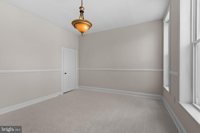 carpeted empty room featuring baseboards