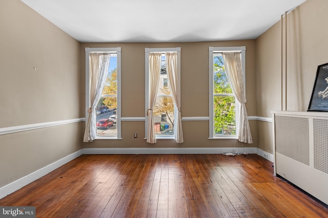 interior space with baseboards, radiator heating unit, and hardwood / wood-style floors