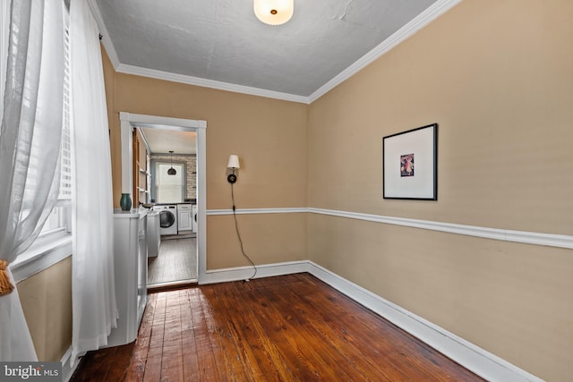 laundry area with wood-type flooring, baseboards, and ornamental molding