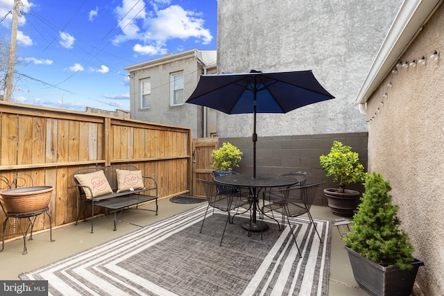 view of patio featuring outdoor dining area and fence