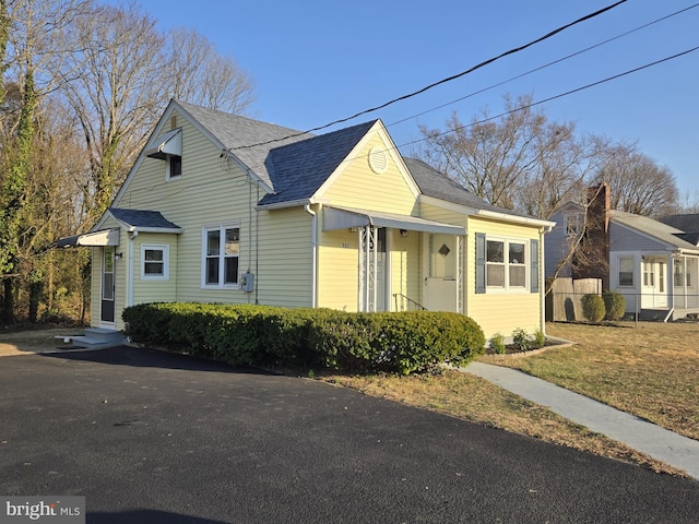 bungalow-style house featuring roof with shingles and fence