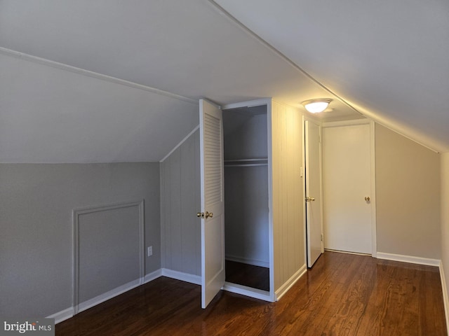 additional living space with baseboards, lofted ceiling, and wood finished floors