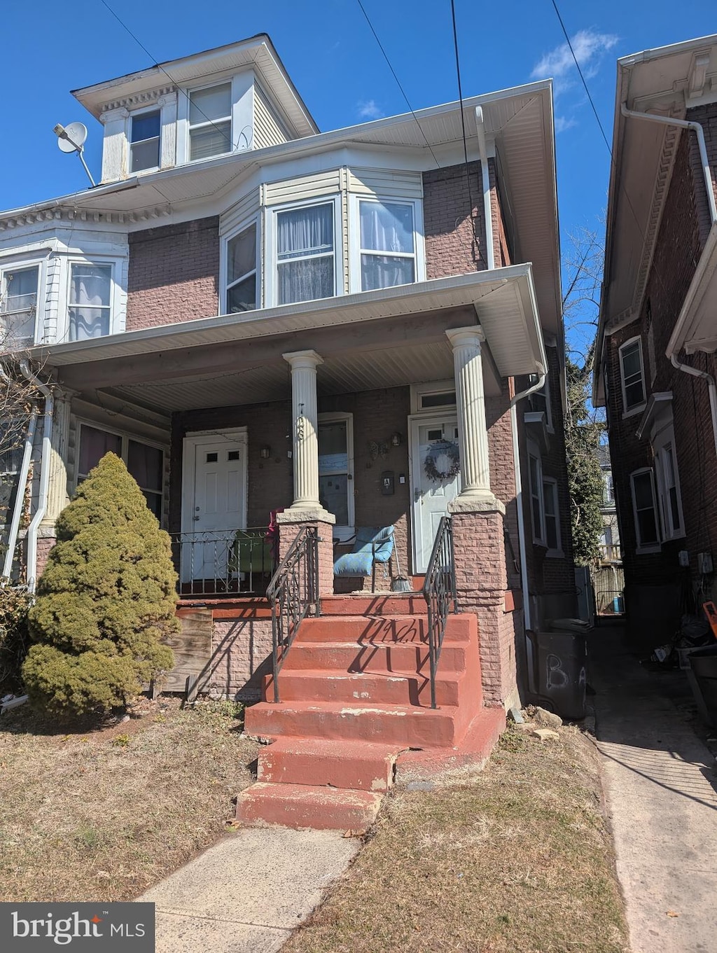 view of front of home with covered porch and brick siding