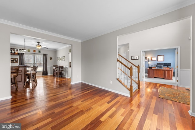 living room with baseboards, crown molding, stairway, and hardwood / wood-style floors