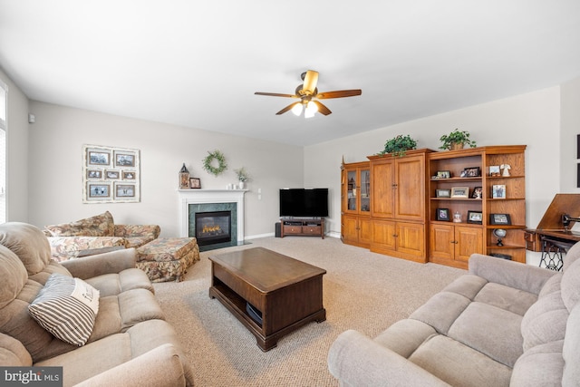 living area with ceiling fan, a high end fireplace, and light colored carpet