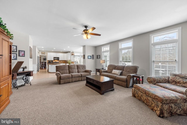 living room with light carpet, a ceiling fan, and recessed lighting