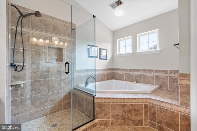 bathroom with a bath, a stall shower, and visible vents