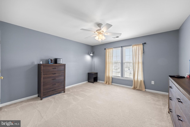 interior space with baseboards, a ceiling fan, visible vents, and light colored carpet