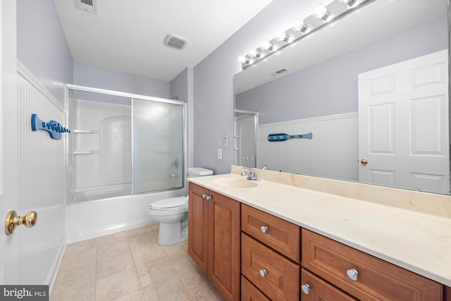 full bathroom with tile patterned flooring, toilet, visible vents, vanity, and combined bath / shower with glass door