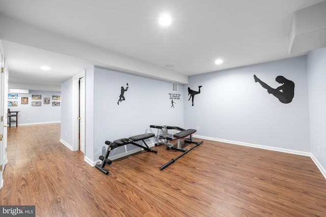 exercise area featuring recessed lighting, wood finished floors, and baseboards