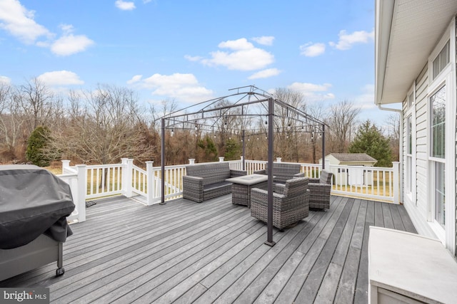 wooden deck with a gazebo, an outdoor hangout area, and an outbuilding