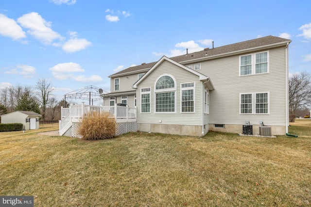 back of house featuring a yard, a deck, an outdoor structure, and central AC unit