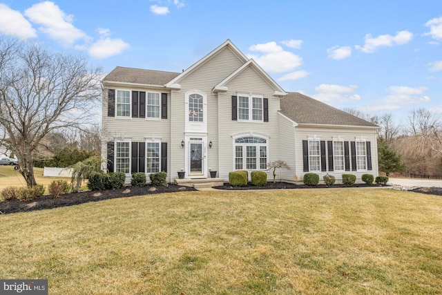 view of front of home featuring a front lawn and roof with shingles