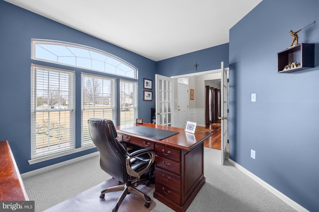 carpeted home office featuring baseboards