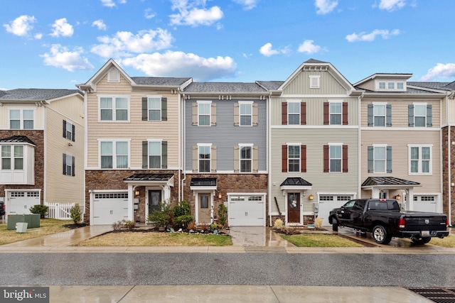 townhome / multi-family property with a garage, a residential view, stone siding, and driveway