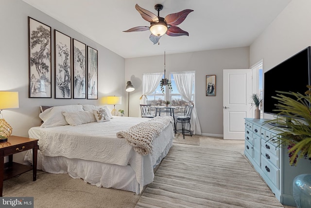 bedroom featuring light carpet, ceiling fan, and baseboards