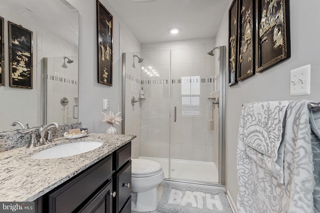 full bath featuring toilet, a shower stall, and vanity