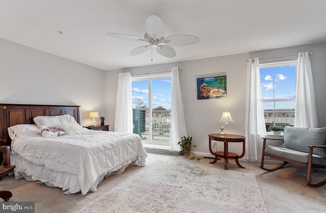 bedroom featuring light carpet, baseboards, a ceiling fan, and access to exterior