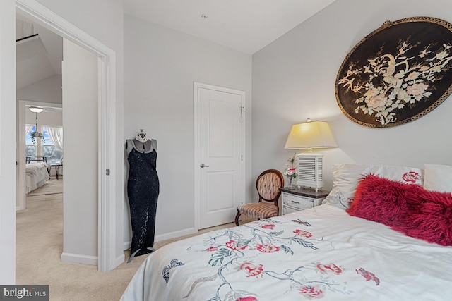 carpeted bedroom with lofted ceiling and baseboards