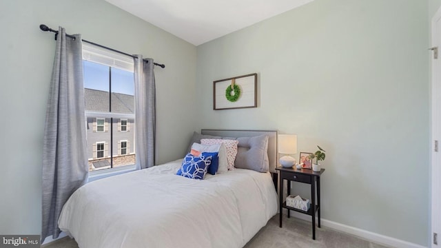 bedroom featuring light carpet and baseboards