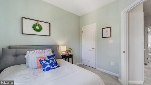 bedroom featuring light carpet and baseboards