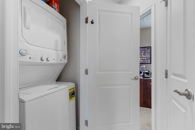 washroom featuring laundry area and stacked washer / dryer