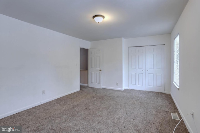 unfurnished bedroom with visible vents, carpet floors, multiple windows, and baseboards