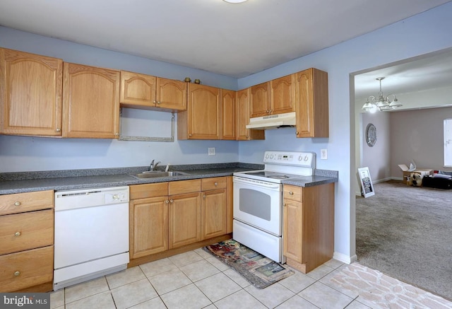 kitchen with white appliances, a sink, under cabinet range hood, dark countertops, and light colored carpet