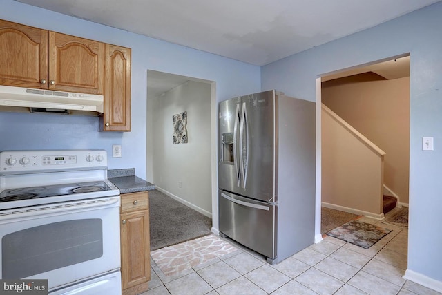 kitchen with under cabinet range hood, light tile patterned flooring, stainless steel fridge with ice dispenser, and electric stove