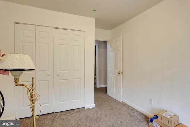 unfurnished bedroom featuring a closet, carpet, and baseboards