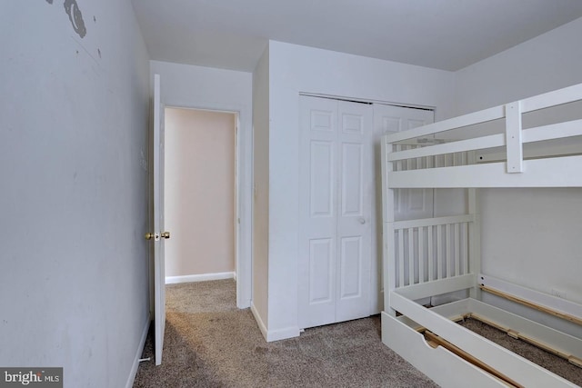 unfurnished bedroom with a closet, baseboards, and carpet floors