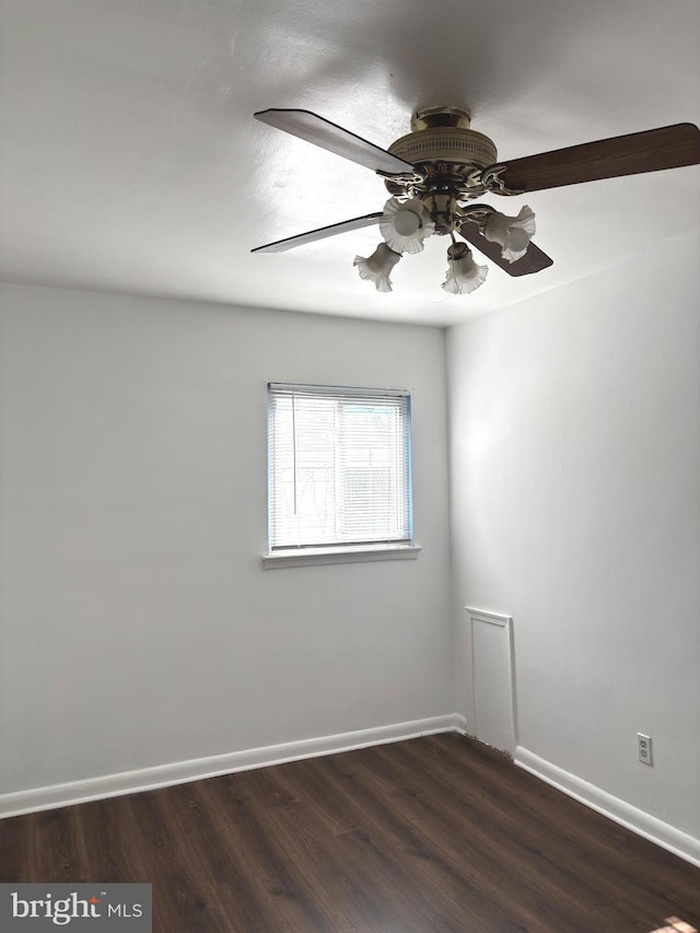 unfurnished room with dark wood-style floors and baseboards