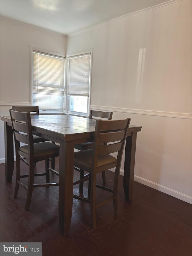 dining area featuring dark wood-type flooring and baseboards