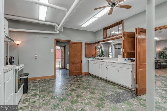 kitchen with baseboards, light countertops, white cabinetry, and tile patterned floors