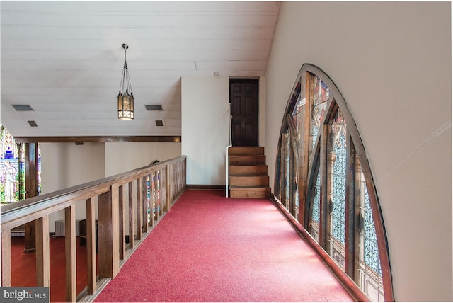 hallway featuring carpet floors, visible vents, and stairway