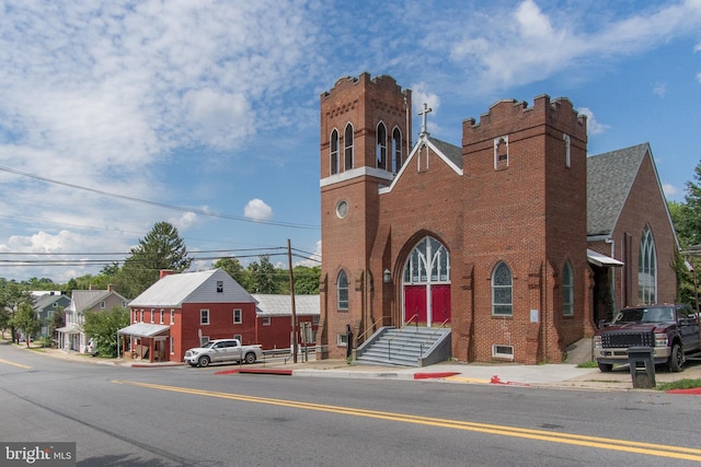 view of front facade with brick siding and a chimney