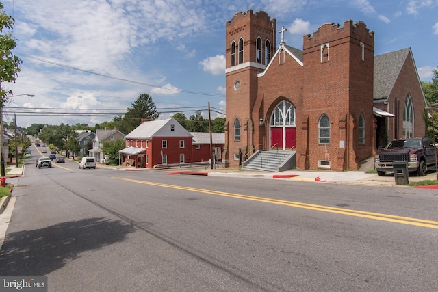 view of road featuring curbs, sidewalks, and street lights