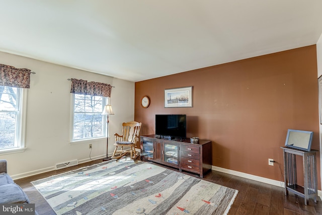 sitting room with visible vents, baseboards, and wood finished floors