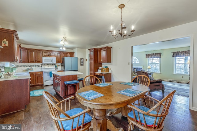 dining space with baseboards, dark wood-style flooring, visible vents, and a notable chandelier